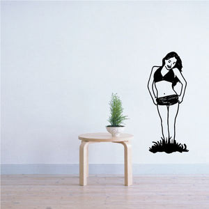 Black decal of a woman in short shorts standing, hands on head