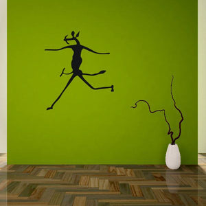 Dancer wall decal: black silhouette with arms spread and flowing dress, on green surface.