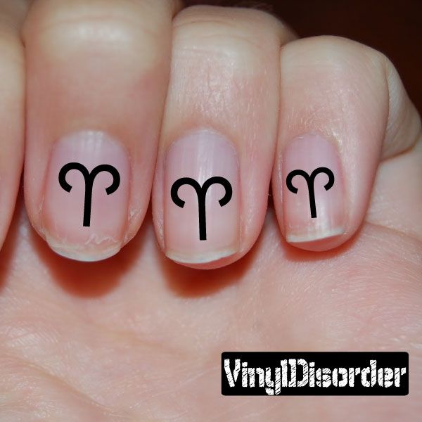 Fingernail art sticker with black Aries symbol on nude nails
