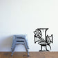 Black cross with flower decal on wall