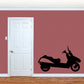 Black scooter decal with side-view riding silhouette on a flat surface.