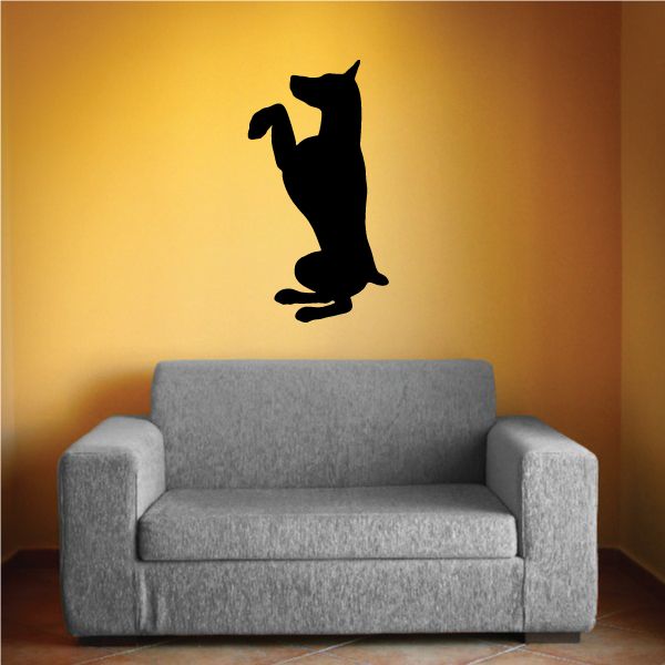 Black begging Doberman Pinscher vinyl decal, standing silhouette on wall above couch