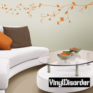 Vinyl branch wall decal with flowing vines and orange leaf accents