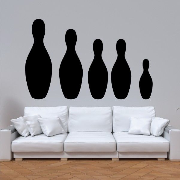 Bowling pins wall decal set with five black pin silhouettes above a white sofa
