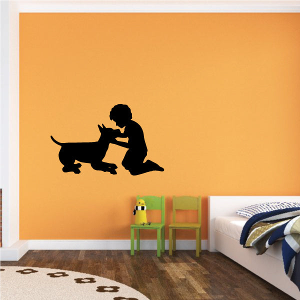 Boy and dog wall decal silhouette, boy kneeling and petting a black dog.