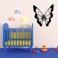 Butterfly wall decal with black wings and white dotted pattern, centered on wall.
