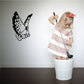 Black butterfly vinyl wall decal with wings spread, centered on the wall