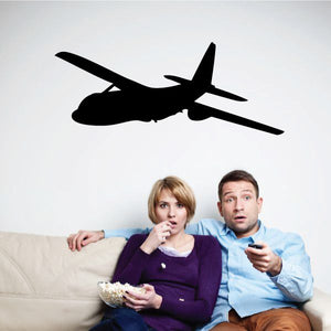 Black airplane silhouette wall decal above couch