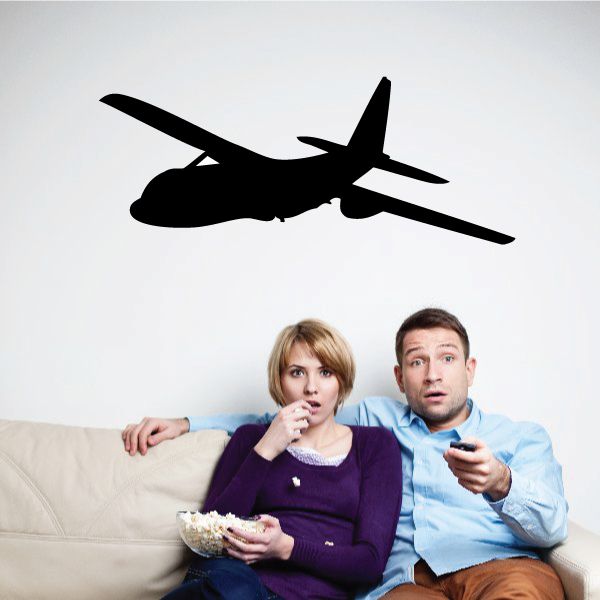 Black airplane silhouette wall decal above couch