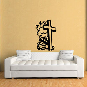 Wall decal featuring a black praying figure beside a cross and tombstone