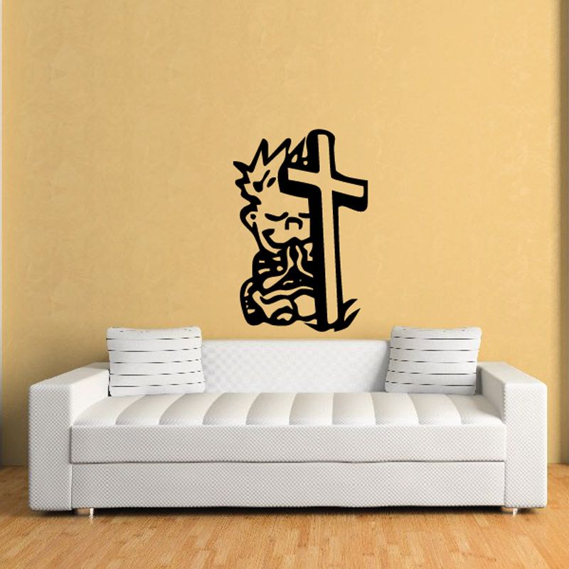 Wall decal featuring a black praying figure beside a cross and tombstone