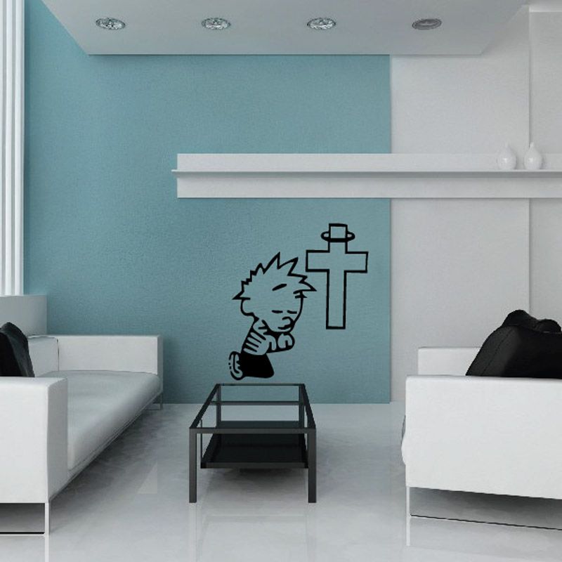 Wall decal of a praying child beside a cross, black outline