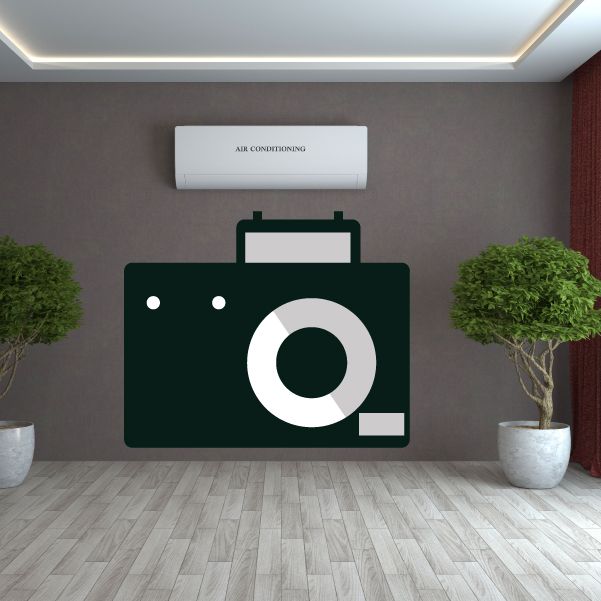 Camera wall decal with dark green body and white lens and strap holes