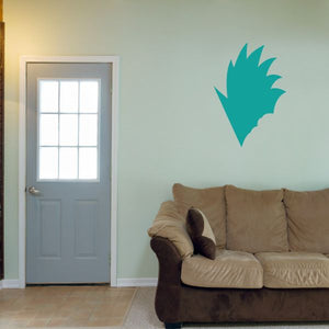 Vinyl wall decal of teal character face silhouette above sofa