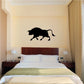 Black bull silhouette decal on a wall above a bed
