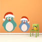 Christmas bird sticker with two penguins wearing Santa hats