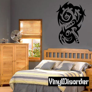 Tribal vinyl wall decal with black curled motifs and two face-like figures