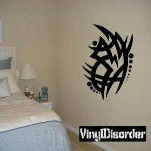 Tribal wall decal featuring a bold black geometric emblem with small dot accents.