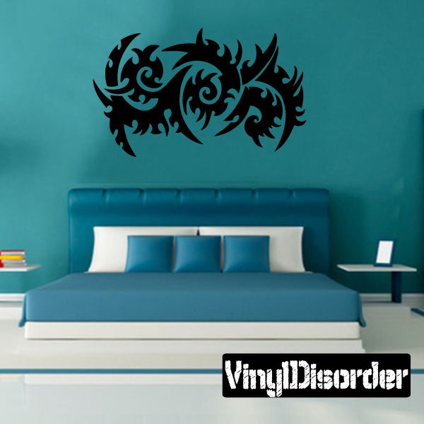 Black tribal vinyl wall decal with ornate swirling pattern above bed