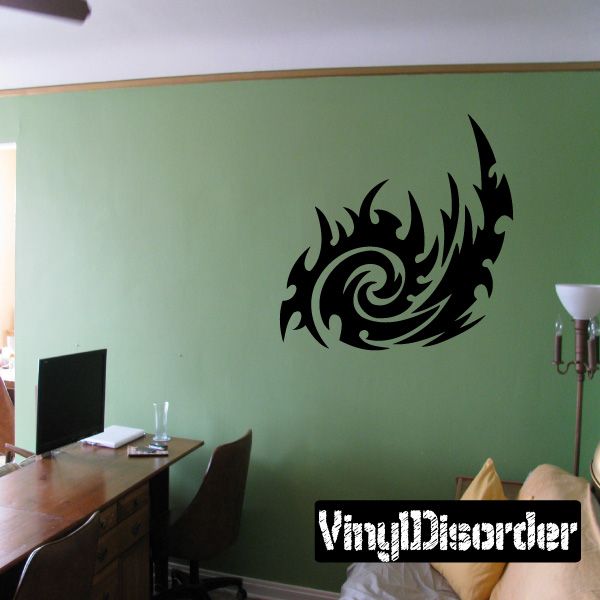 Tribal vinyl wall decal with black swirl and feather-like shapes on a green surface