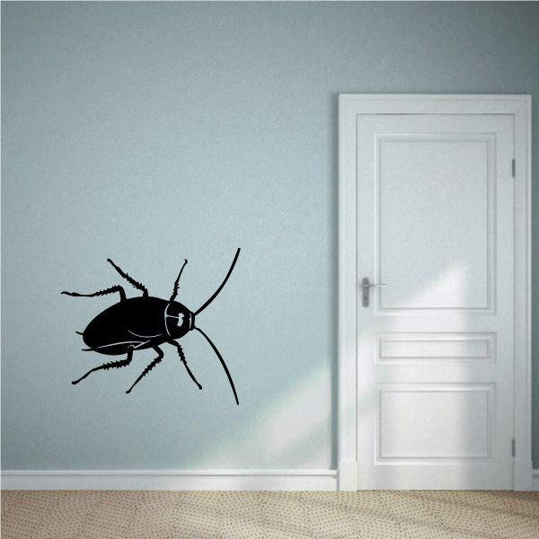 Black cockroach wall decal with antennae and legs, positioned on a wall
