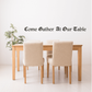 Wall decal with cursive text: “Come Gather At Our Table”