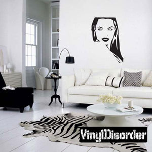 Wall decal with black-and-white illustrated woman face above sofa