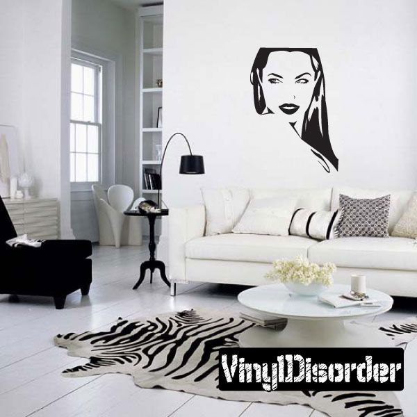 Wall decal with black-and-white illustrated woman face above sofa