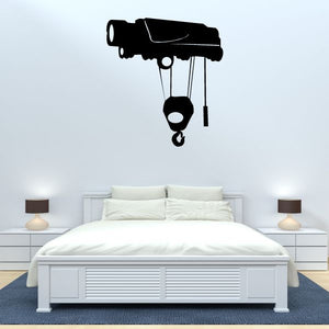 Crane pulley wall decal with black hoist, ropes, and hook above bed