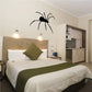 Black spider wall decal with long legs, perched on a light wall