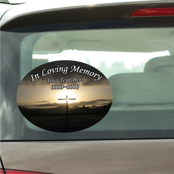 Oval sticker: sunrise sky, black cross, and In Loving Memory text