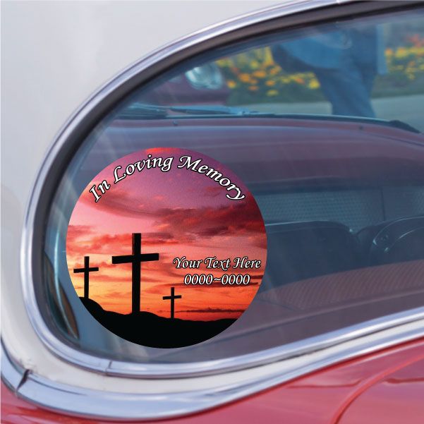 Round memorial sticker with black cross silhouettes and sunset gradient, 'In Loving Memory' text