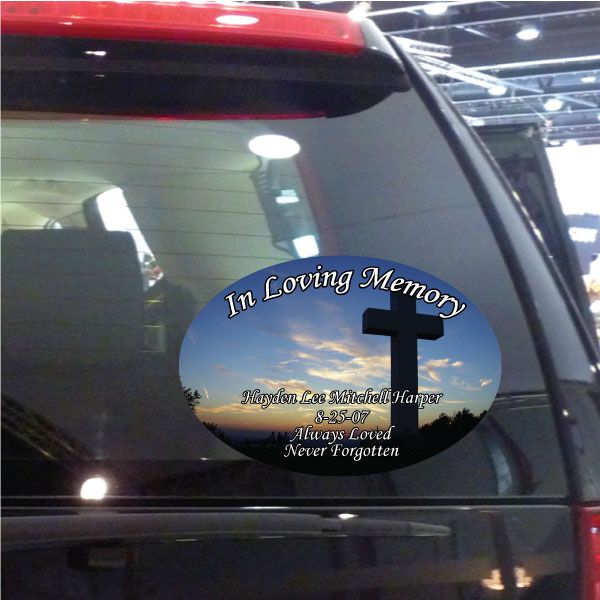 Oval memorial sticker with black cross and 'In Loving Memory' text