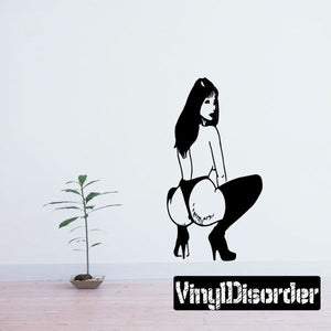 Wall decal of a crouched woman in heels, black-and-white silhouette