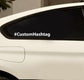 Custom hashtag decal with white “#CustomHashtag” text on dark car window