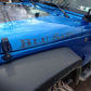 One-line text decal on blue car hood with large dark lettering.