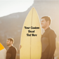 Yellow surfboard with custom text vinyl decal, black lettering centered on board.