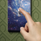 Vinyl switchplate wrap sticker skin with colorful galaxy pattern, hands applying