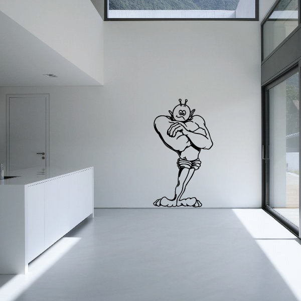 Alien wall decal of a smiling cartoon alien holding a book-like object