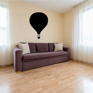 Descending hot air balloon decal with black silhouette over a couch