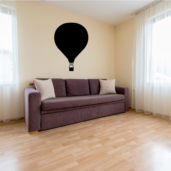 Descending hot air balloon decal with black silhouette over a couch