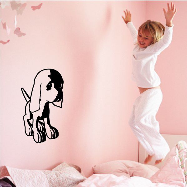 Cartoon dog decal with black outline and sitting pose on a light wall