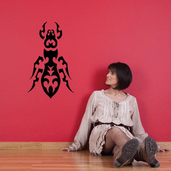 Tribal ant wall decal, black ornate silhouette with symmetrical flourishes.