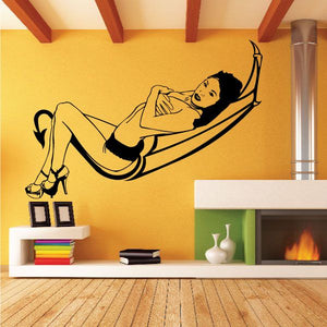 Black devil girl wall decal in lounging pose on a curved hammock