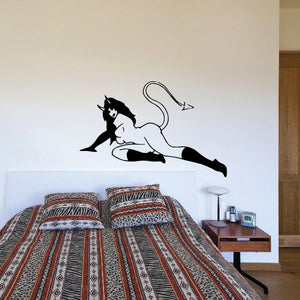 Devil girl lying on side wall decal, black and white silhouette with curled tail.