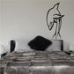 Dolphin dive wall decal with stylized swimmer, black outline, above bed pillows