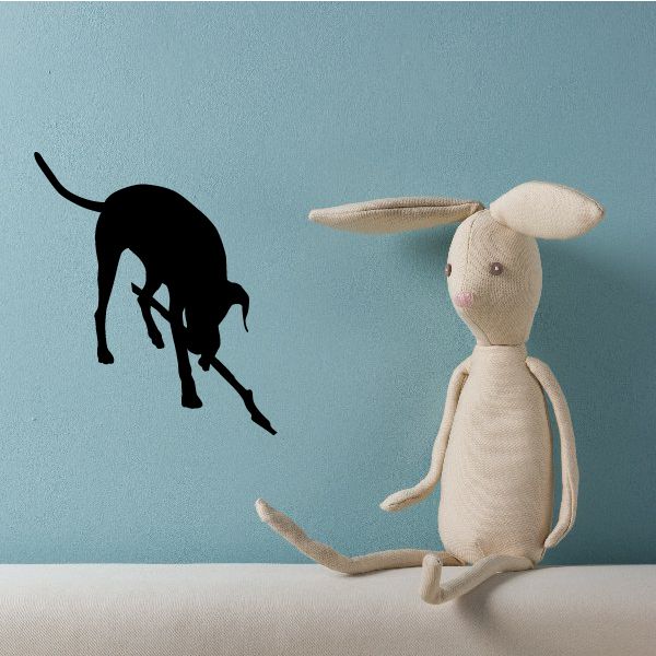 Dog picking up stick decal: black dog silhouette holding a stick