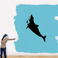 Dolphin swimming up decal, black silhouette on light blue rectangle.