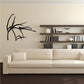 Wall decal of a black dragonfly perched on a branch stick