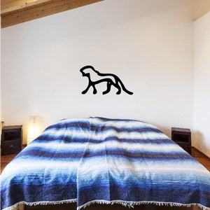 Black animal wall decal with hieroglyphic-style silhouette on a light wall